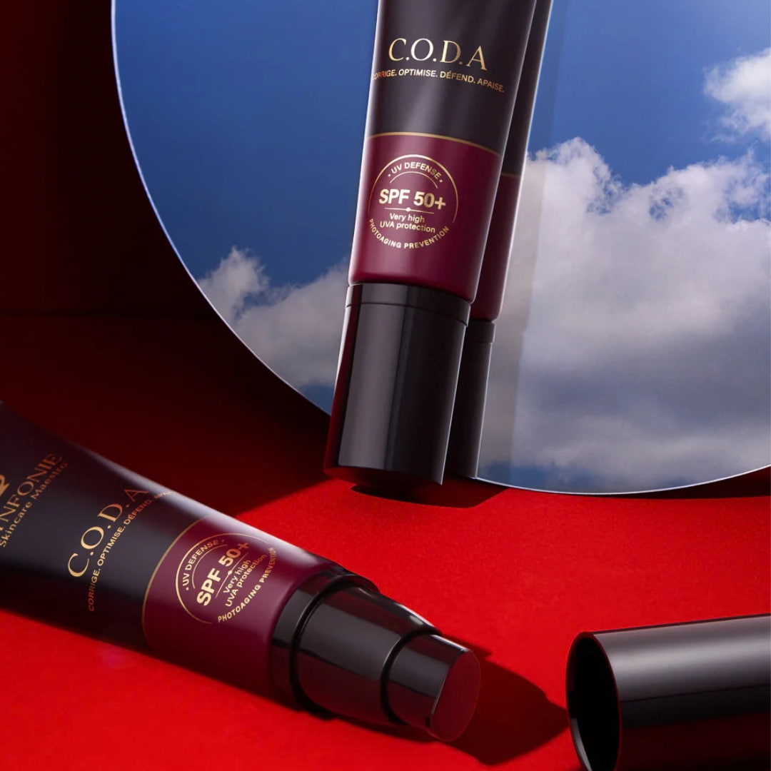 SPF 50+ C.O.D.A. Synfonie Skincare Maestro na tle lustra i nieba – krem przeciwsłoneczny z wysoką ochroną UVA i UVB